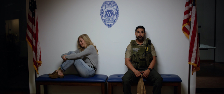 (L-R) Lindsay LaVanchy as Ellery Scott and Jon Huertas as Officer Rico Martinez in the horror / thriller “INITIATION,” a Saban Films release. Photo Courtesy of Saban Film