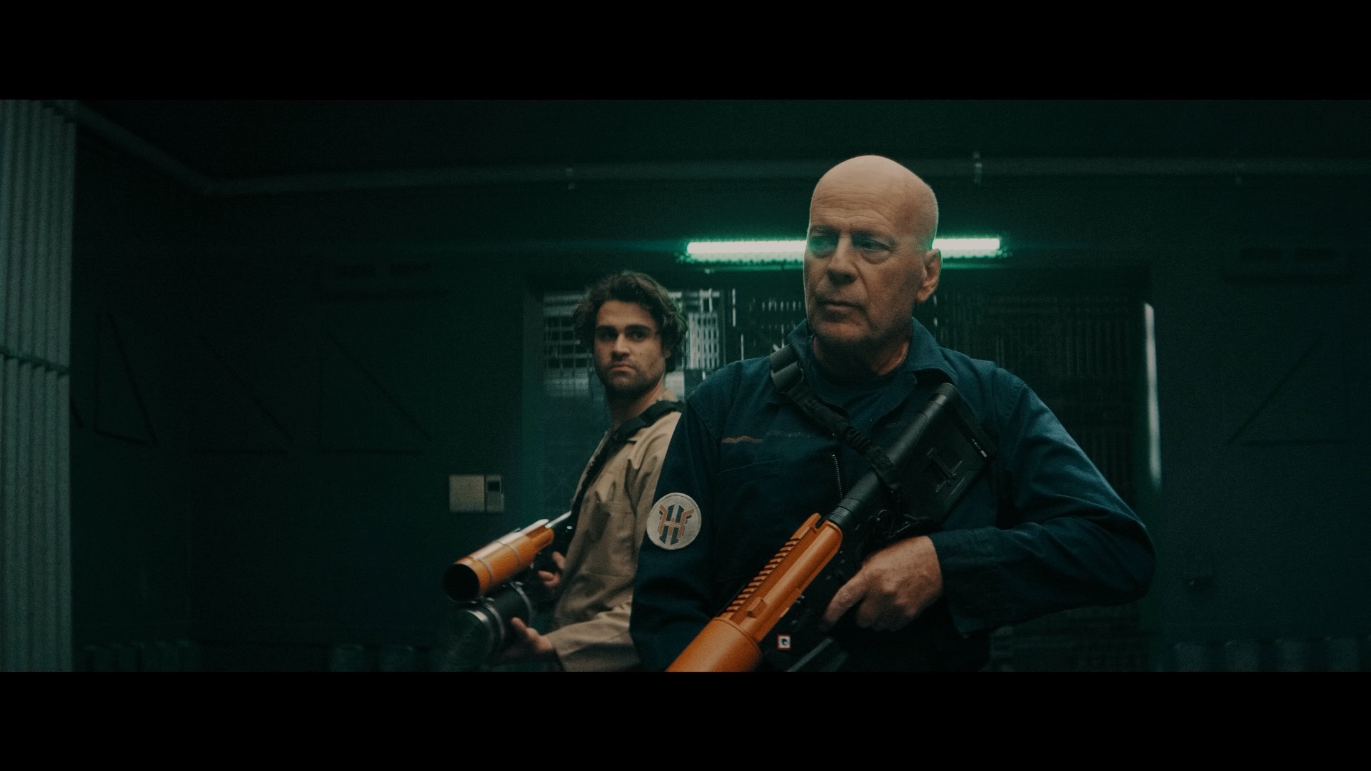 (L - R) Cody Kearsley as Noah and Bruce Willis as Clay Young in the sci - fi/action film, BREACH , a Saban Films release. Photo courtesy of Saban Films